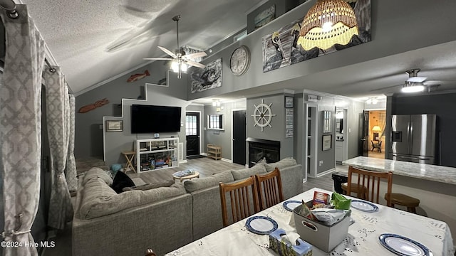 dining area with hardwood / wood-style flooring, ceiling fan, a textured ceiling, and vaulted ceiling