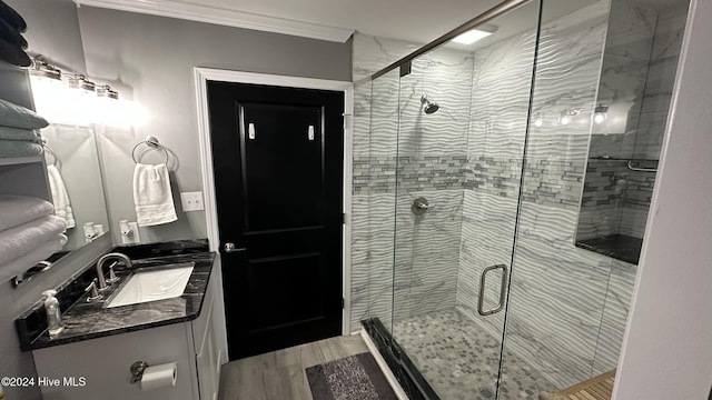 bathroom featuring crown molding, a shower with door, vanity, and hardwood / wood-style floors