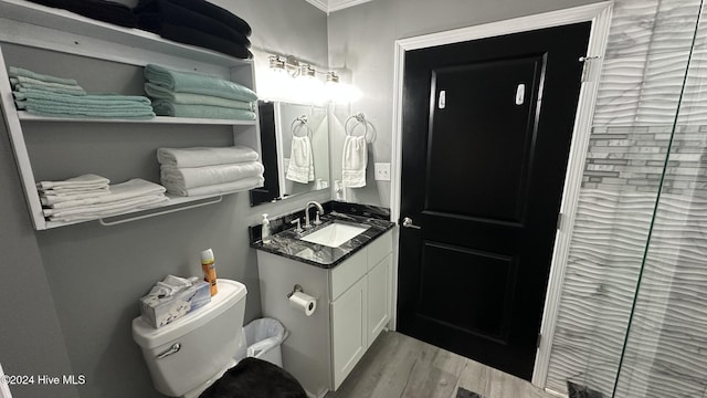 bathroom with hardwood / wood-style flooring, vanity, toilet, and ornamental molding