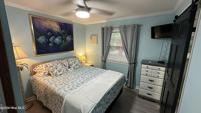 bedroom featuring dark wood-type flooring, ceiling fan, a barn door, ornamental molding, and a textured ceiling