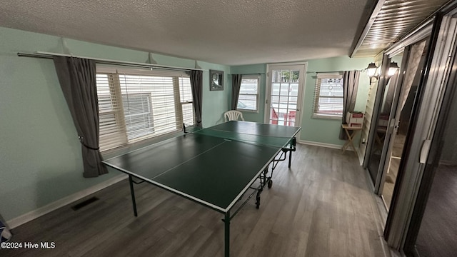 rec room featuring a textured ceiling and hardwood / wood-style flooring