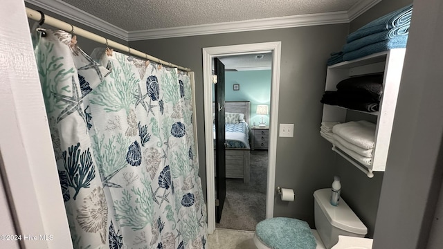 bathroom featuring toilet, a textured ceiling, and ornamental molding