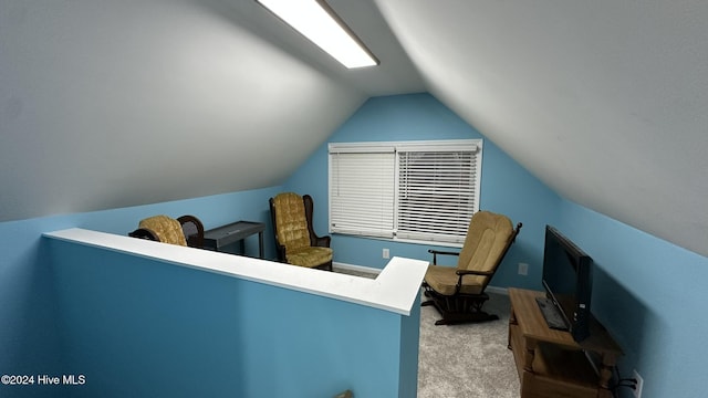 interior space featuring light colored carpet and lofted ceiling