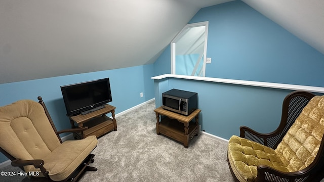 living area with carpet floors and vaulted ceiling