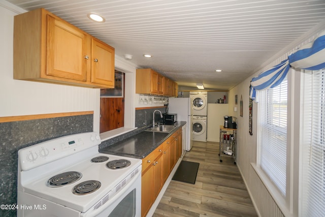 kitchen featuring light wood-type flooring, sink, stacked washer and dryer, and electric stove