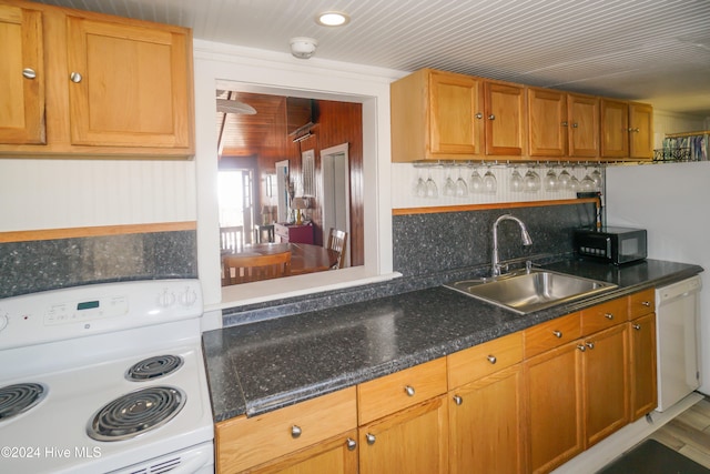 kitchen featuring backsplash, white dishwasher, range with electric stovetop, and sink