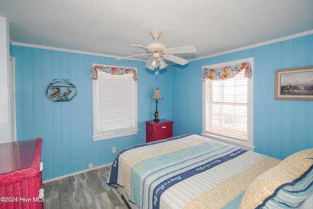 bedroom with ceiling fan, crown molding, and wood-type flooring