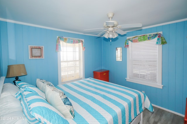 bedroom with dark hardwood / wood-style floors, ceiling fan, and crown molding