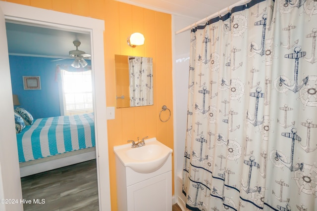 bathroom with wooden walls, vanity, wood-type flooring, and ceiling fan