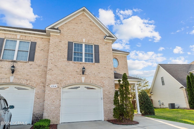 view of front of property with a garage and central air condition unit