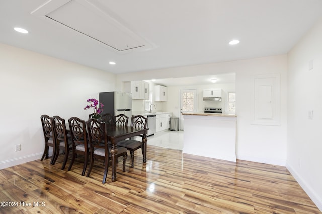 dining room with light wood-type flooring and sink