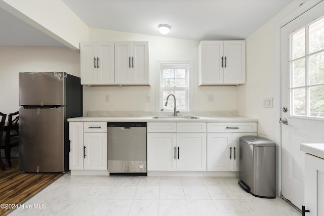 kitchen featuring white cabinetry, sink, lofted ceiling, and appliances with stainless steel finishes