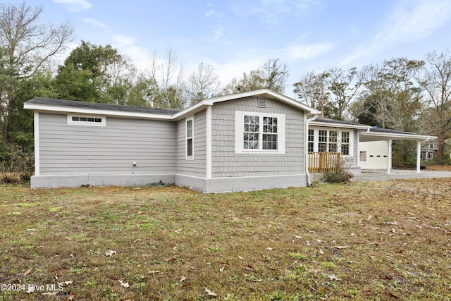 view of side of home featuring a yard and a carport