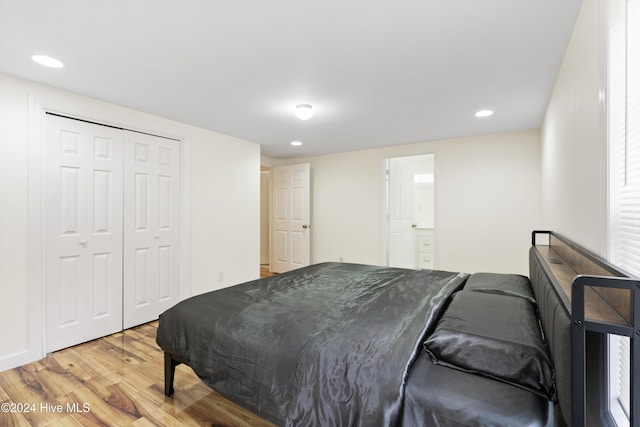 bedroom with ensuite bathroom, a closet, and wood-type flooring