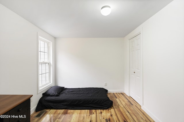 bedroom with multiple windows and light hardwood / wood-style flooring