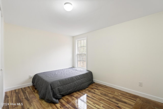 bedroom with dark wood-type flooring