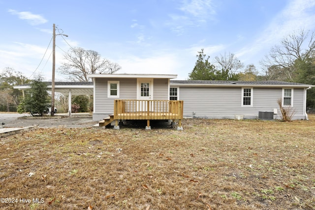 back of property with a deck and central AC