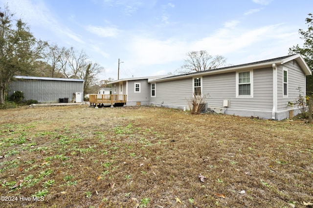 rear view of house featuring a lawn and a wooden deck