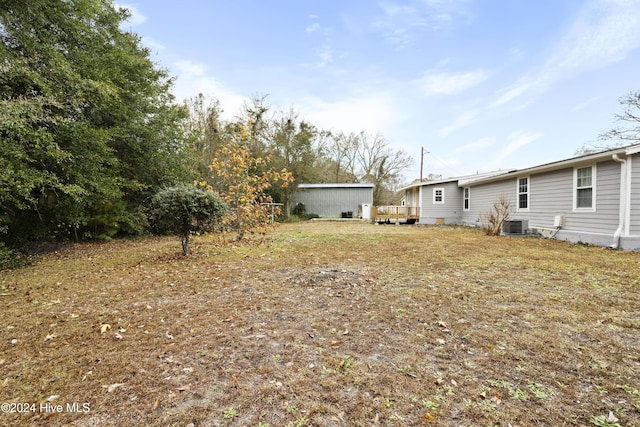 view of yard featuring central air condition unit and a wooden deck