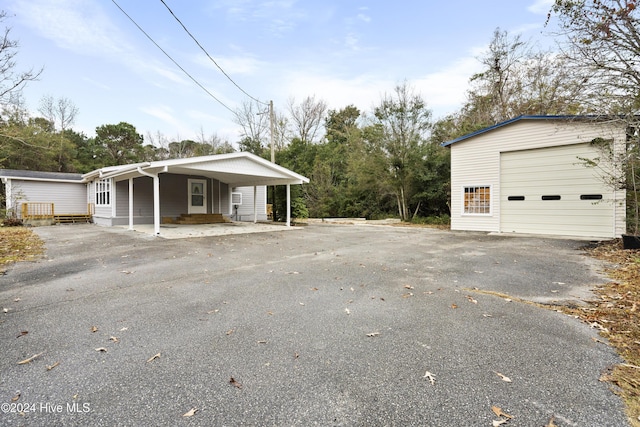 view of front of house with an outbuilding, covered porch, and a garage