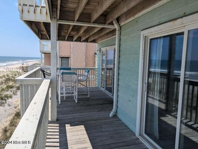 balcony with a deck with water view and a beach view