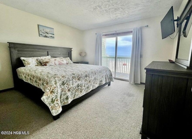 carpeted bedroom featuring access to exterior and a textured ceiling