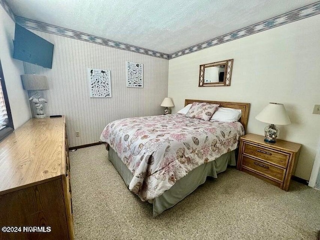 bedroom with a textured ceiling and light colored carpet