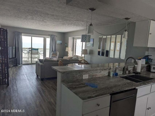 kitchen featuring dishwasher, sink, hanging light fixtures, a wealth of natural light, and white cabinetry