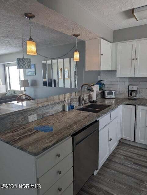 kitchen with pendant lighting, dishwasher, white cabinets, sink, and kitchen peninsula