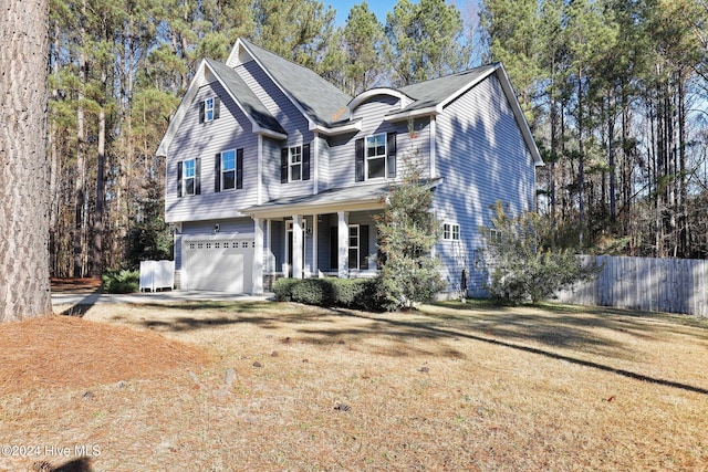 view of front property featuring a porch, a garage, and a front lawn