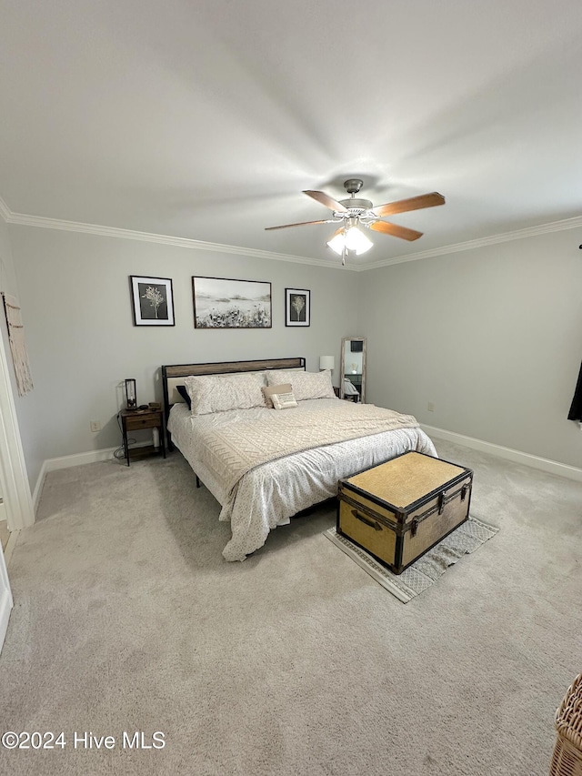 carpeted bedroom featuring ceiling fan and crown molding