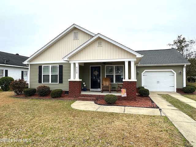 craftsman-style home with covered porch, a front yard, and a garage