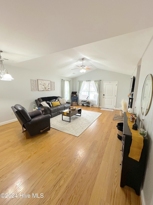 living room with ceiling fan, light wood-type flooring, and vaulted ceiling