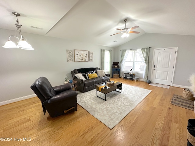 living room with lofted ceiling, light wood-type flooring, and ceiling fan with notable chandelier