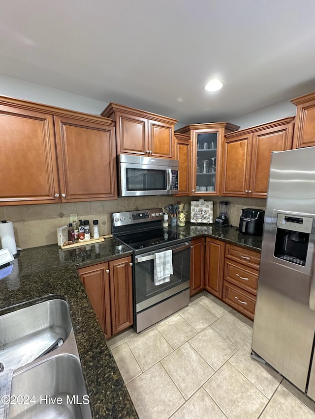 kitchen featuring decorative backsplash, light tile patterned floors, and stainless steel appliances