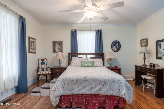 bedroom featuring hardwood / wood-style floors, ceiling fan, and crown molding