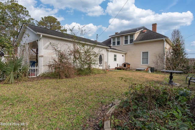 back of house with a lawn