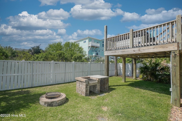 view of yard with a wooden deck, a fenced backyard, and an outdoor fire pit