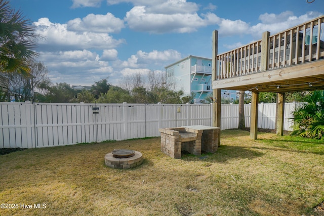 view of yard featuring a fire pit, a wooden deck, and fence