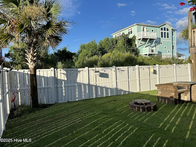 view of yard with fence and an outdoor fire pit