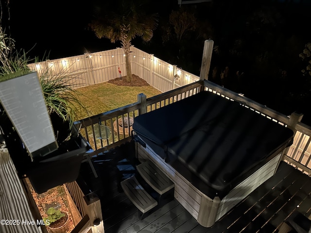 exterior space featuring a yard, a hot tub, and a fenced backyard