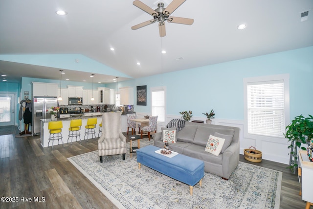 living room featuring vaulted ceiling, ceiling fan, a healthy amount of sunlight, and dark hardwood / wood-style floors