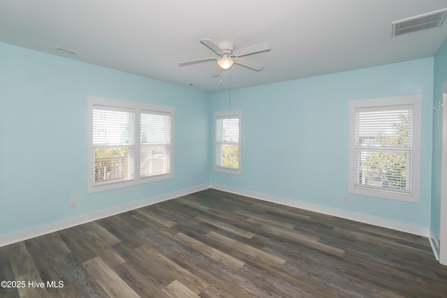 unfurnished room with dark wood-style floors, baseboards, ceiling fan, and visible vents