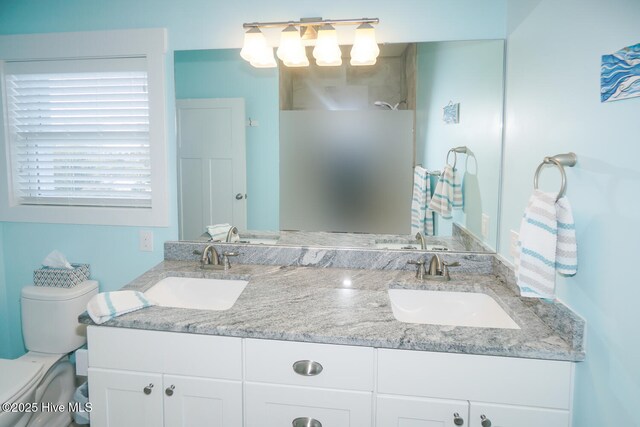 full bathroom featuring toilet, walk in shower, a sink, and double vanity
