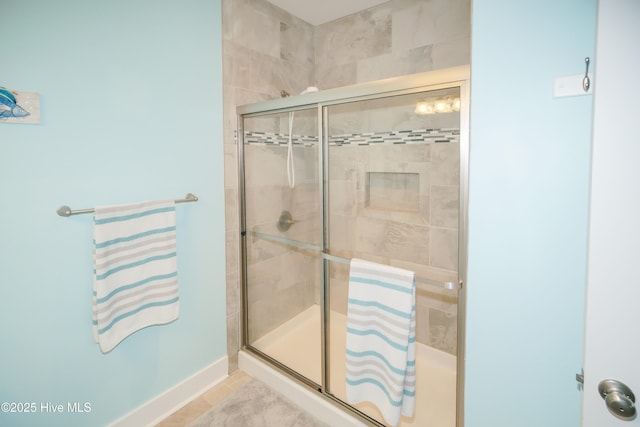 bathroom with baseboards and a stall shower