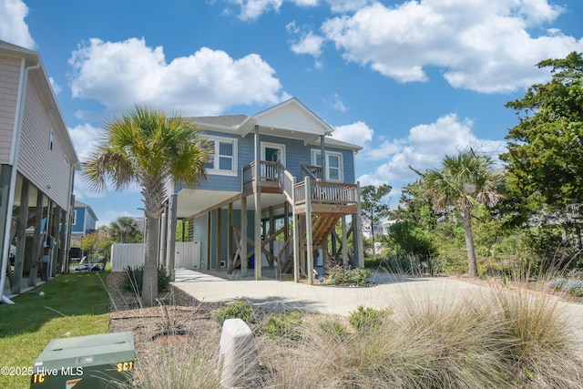 beach home featuring a carport, covered porch, and stairway