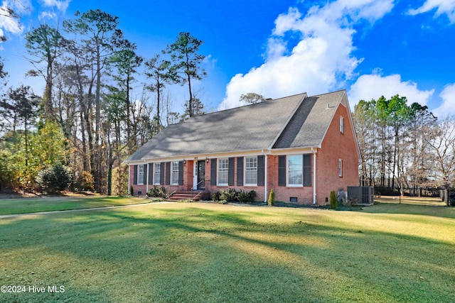 view of front of property with central AC and a front yard