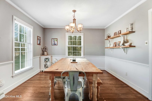 dining space with dark wood-type flooring, a chandelier, and ornamental molding