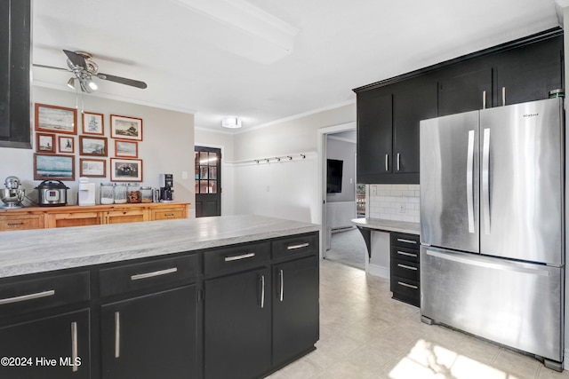 kitchen featuring ceiling fan, ornamental molding, backsplash, and stainless steel refrigerator