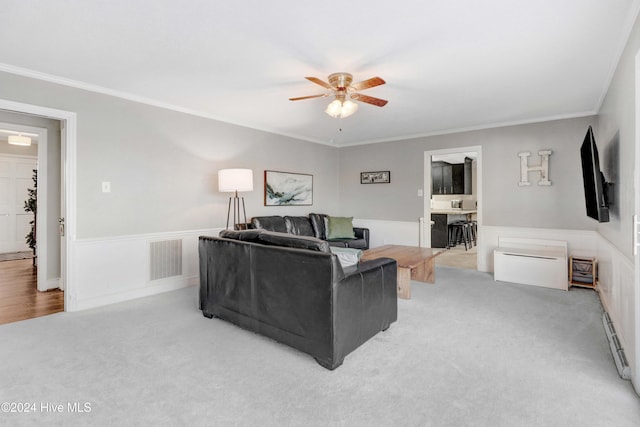 living room featuring light carpet, ceiling fan, and ornamental molding